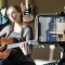 musician performing live acoustic session while viewer watches online