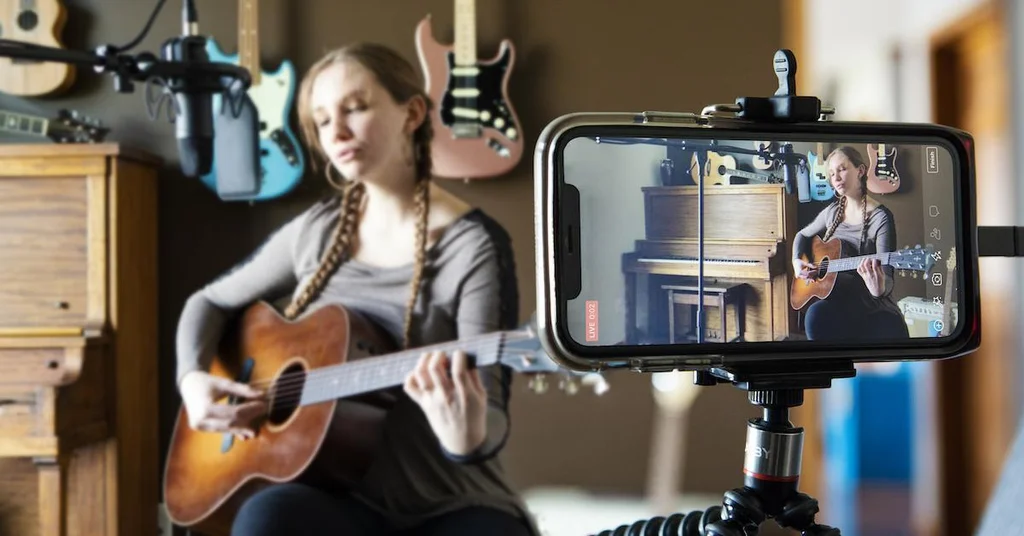 musician performing live acoustic session while viewer watches online
